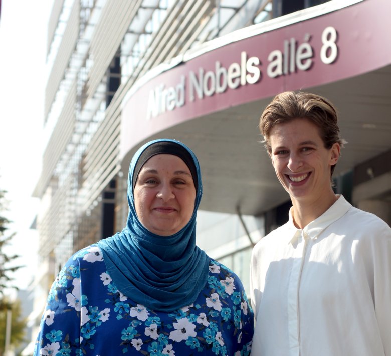 Bild som visar Student- och doktorandombuden. Från vänster: Nazira Hammoud Shahwan och Ninna Oom. De ser glada ut och står framför byggnaden Alfred Nobels Allé 8.