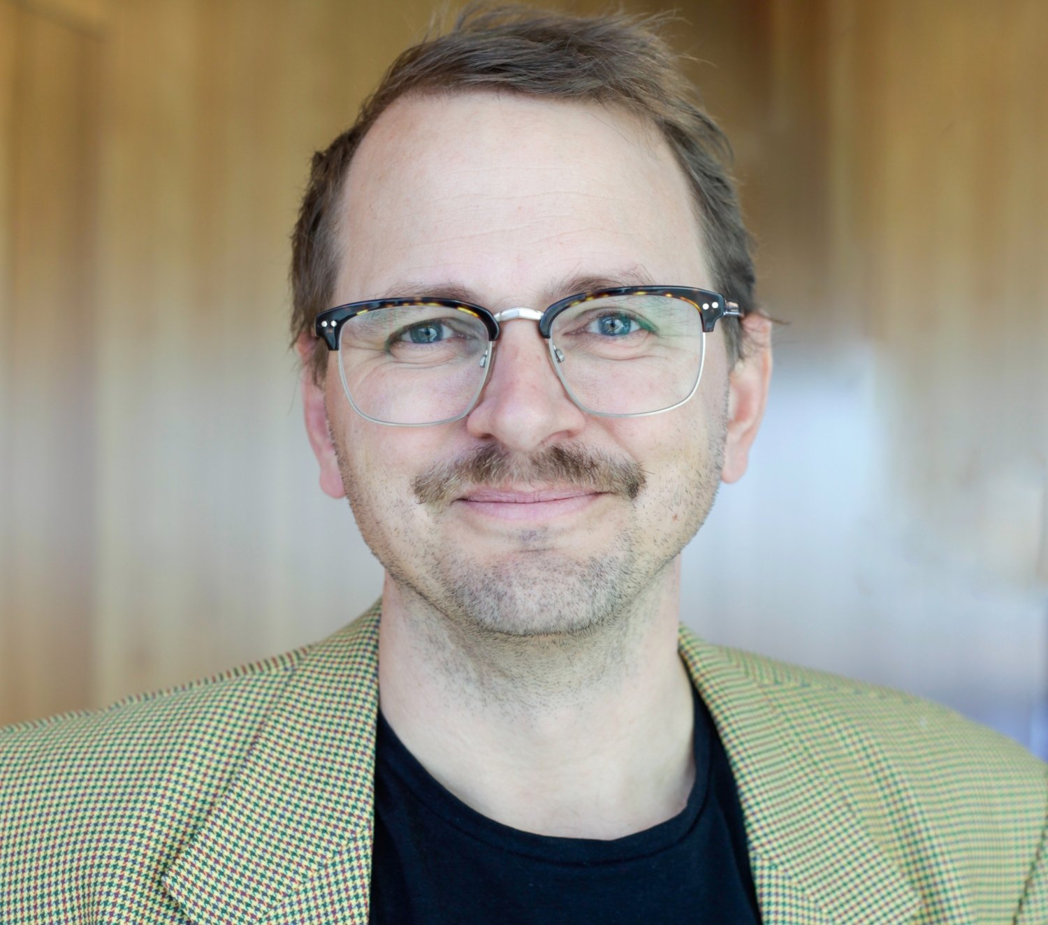 Porträtt av man i grön skjorta.