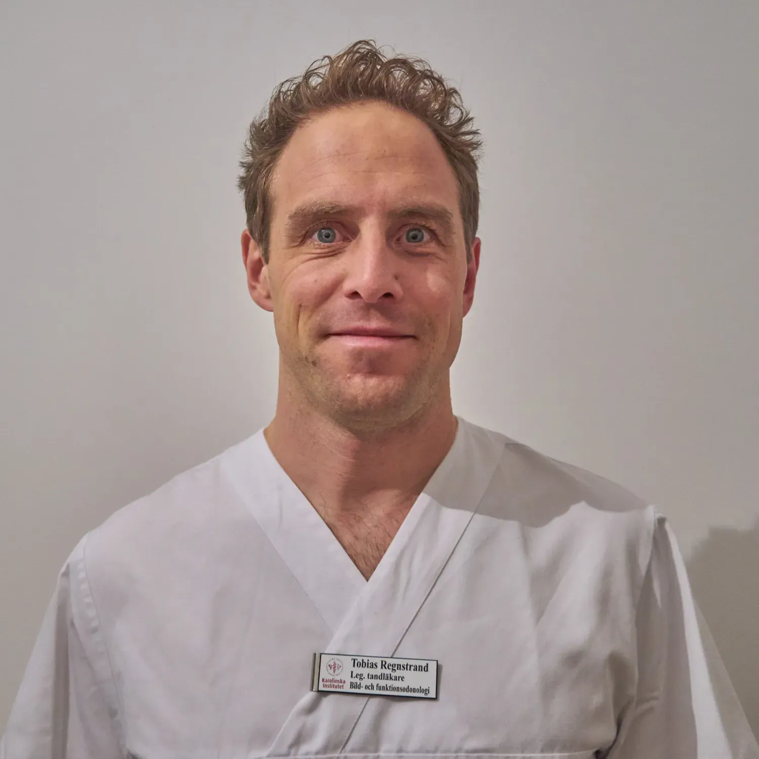 Porträtt av man i vit rock.