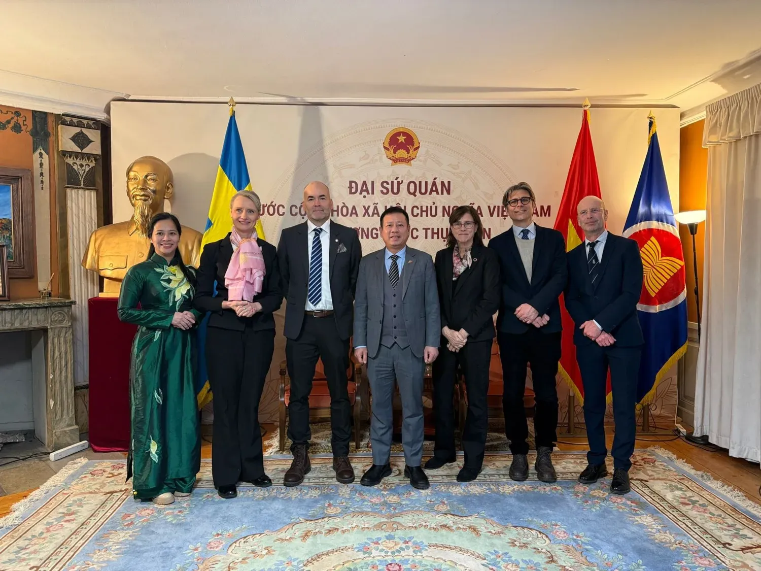 Gruppbild framför Sveriges och Vietnams flaggor på Vietnamesiska ambassaden.