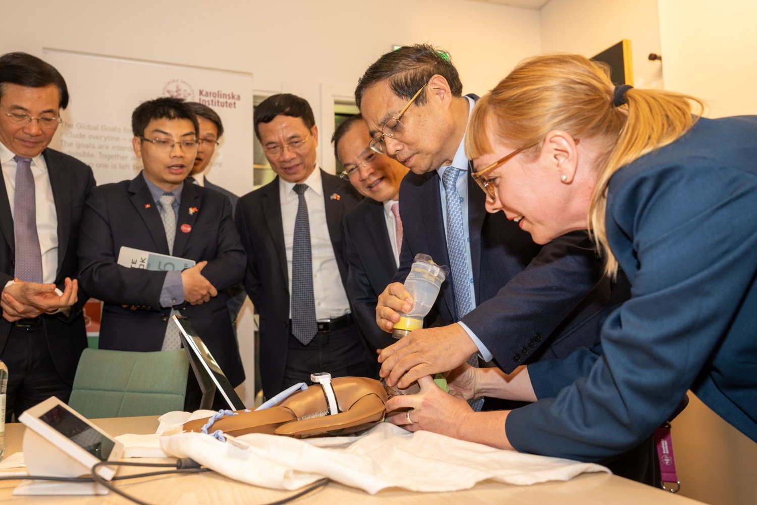 Vietnams premiärminister Pham Minh Chinh provar på läromedlen för att lära ut HLR till nyfödda med hjälp av Susanna Myrnerts Höök.