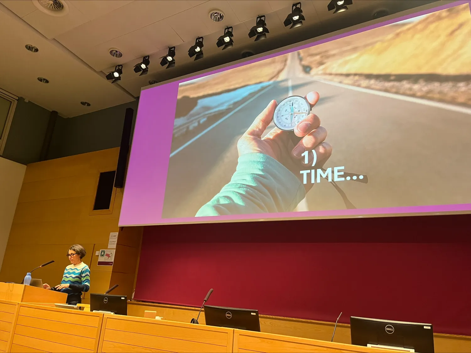 Viriginia Braun, professor vid University of Auckland, Nya Zeeland, föreläste på KI den 4 oktober 2024. Hon står vid ett podium och hennes Powerpointbild om ”Time” syns på skärmen.