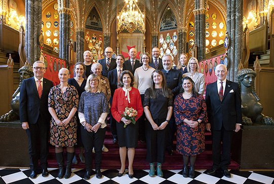 Gruppbild från Bååtska palatset i Stockholm med drottningen i mitten omgiven av forskare som mottagit stipendium.
