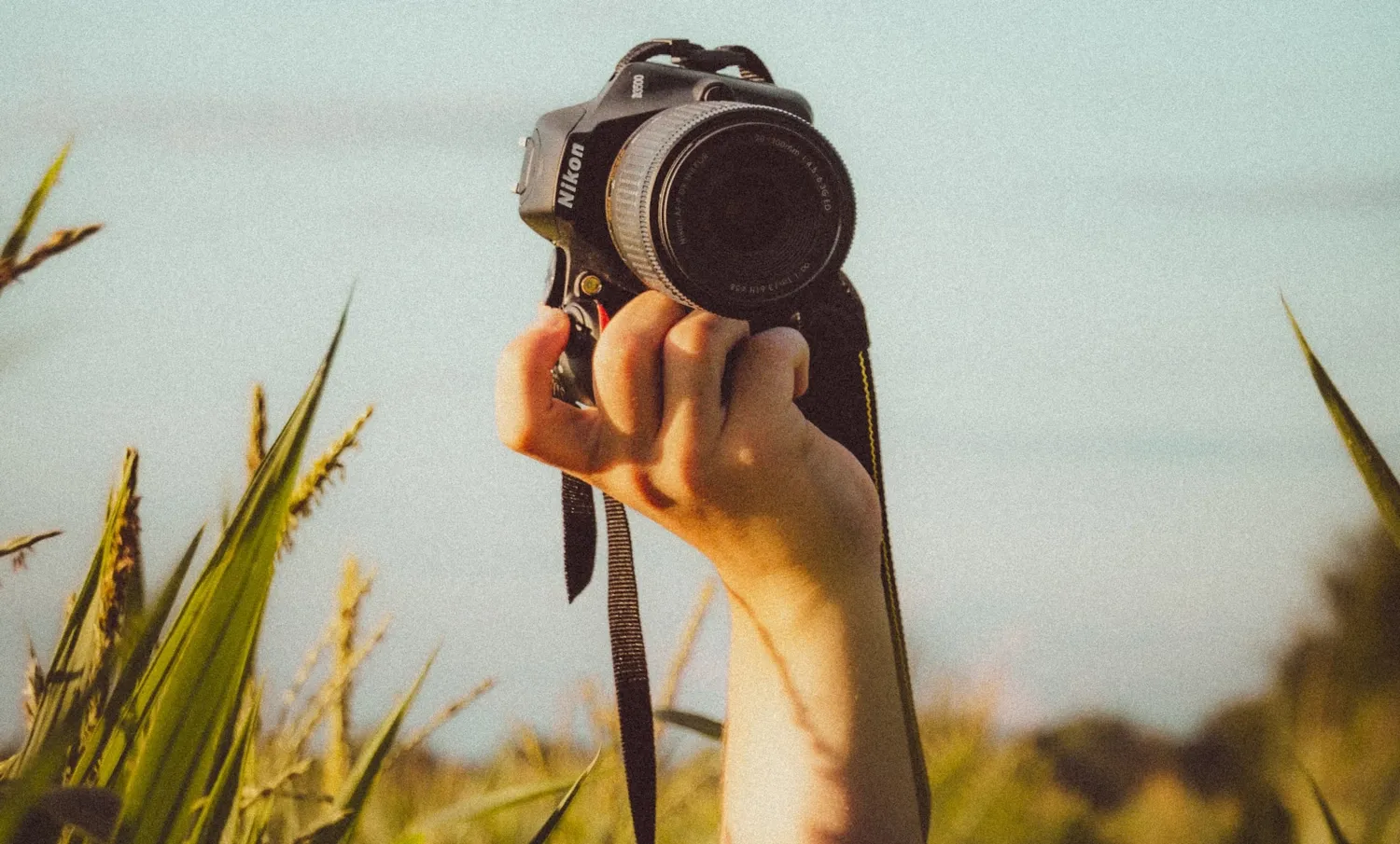 Bilden visar en hand som håller upp en kamera.