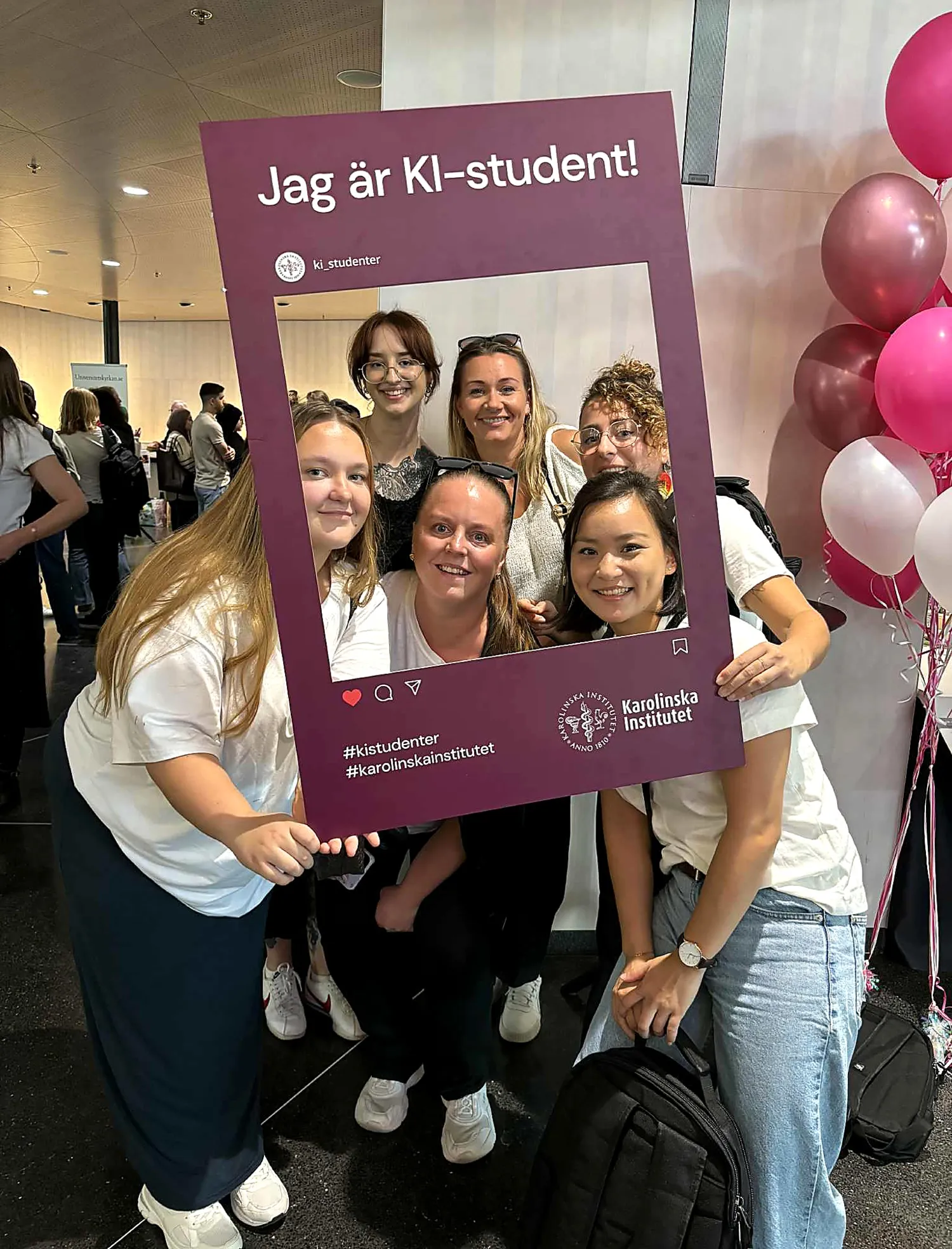 Glada studenter på arbetsterapeutprogrammet fotograferar sig med fotoram under mässan.