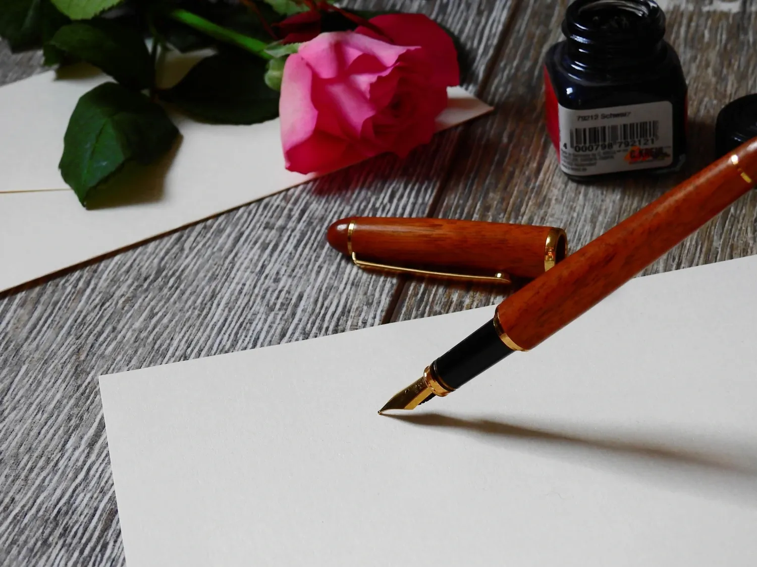 Penna med bläckhorn på vitt papper.