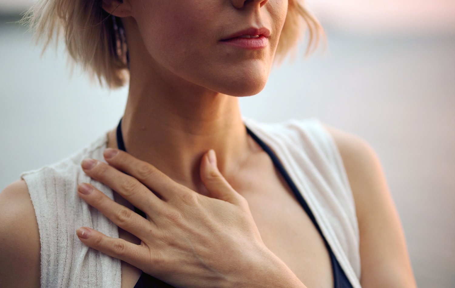 Kvinna som håller en hand på sin hals