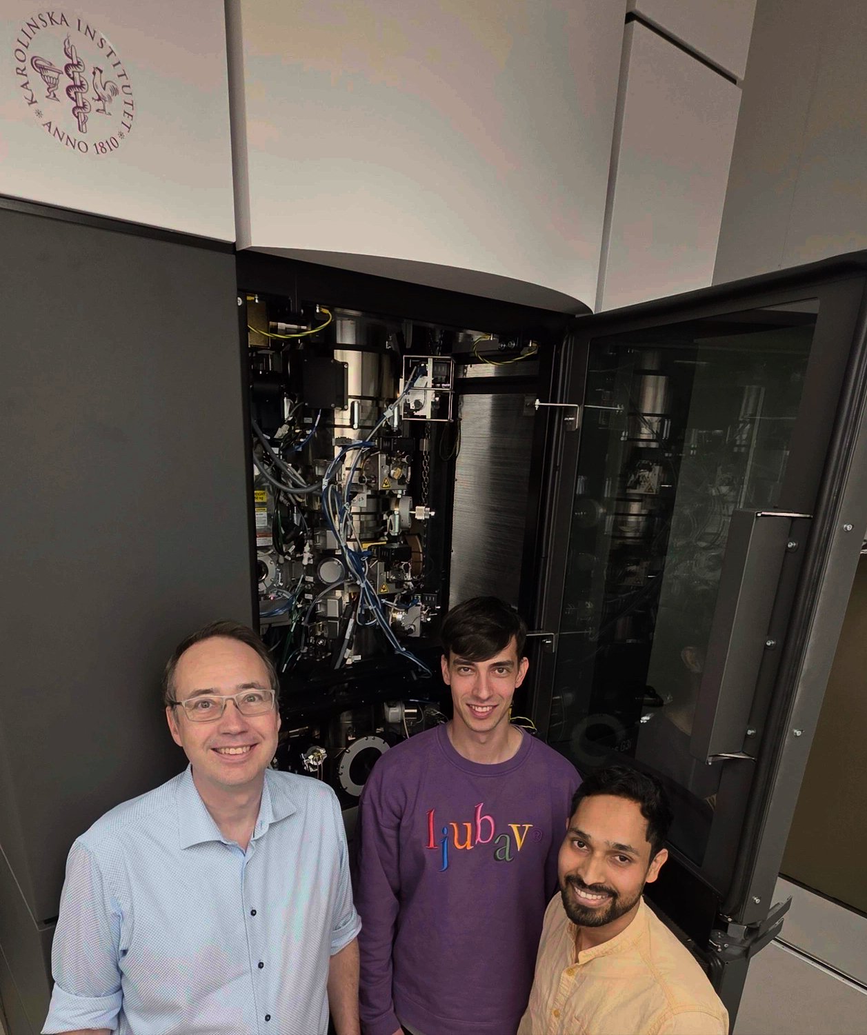 Tre män vid en maskin.