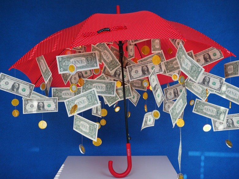 Regnar sedlar och mynt från ett paraply