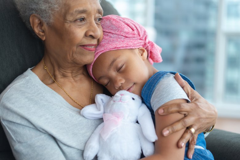 Photo of child with leukemia sitting in her grandma's lap.