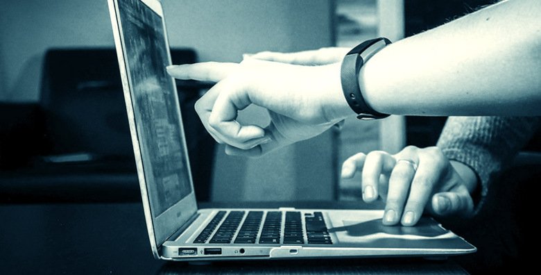 Bilden visar två personer som tittar på en datorskärm.