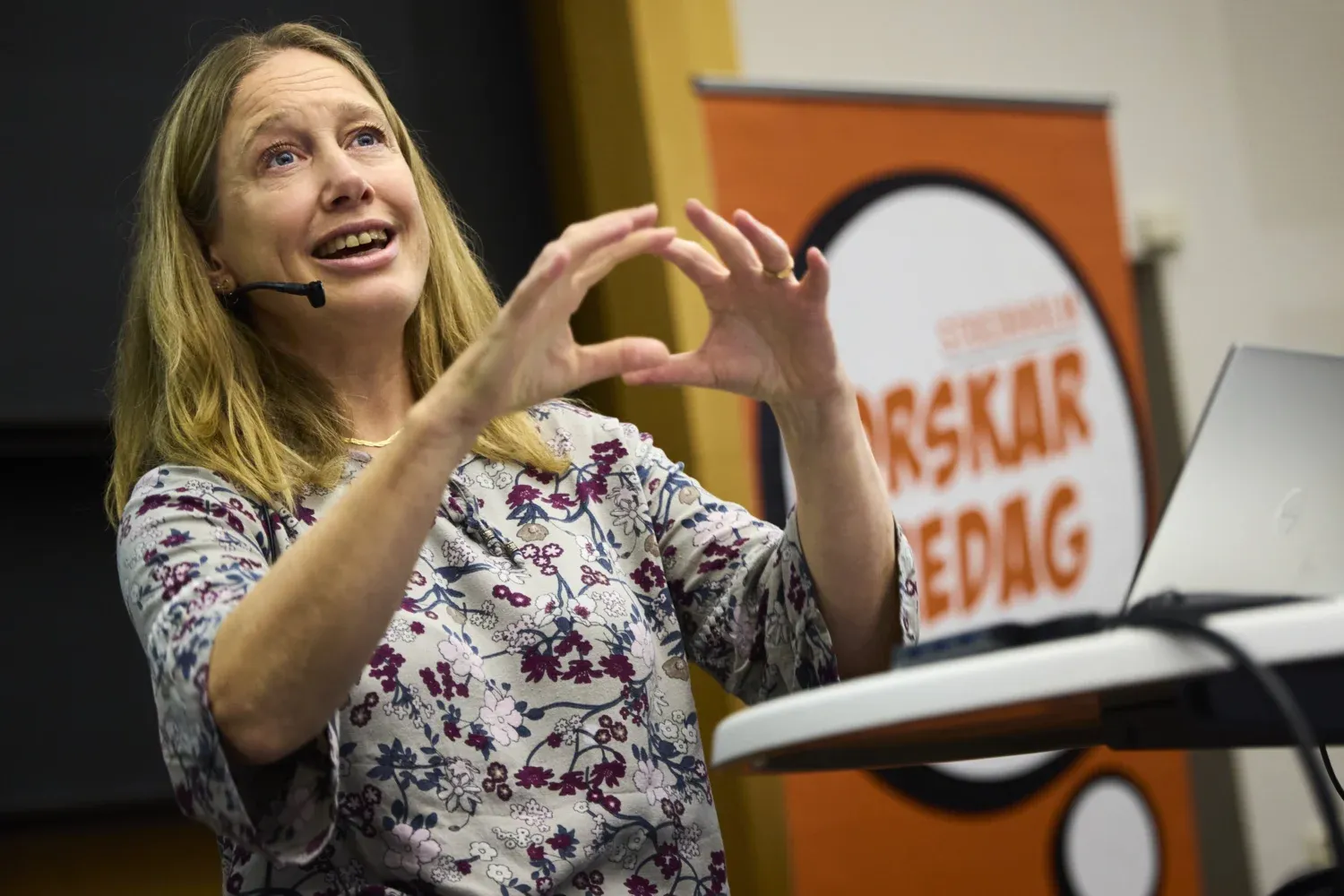 Kvinna föreläser på en scen.