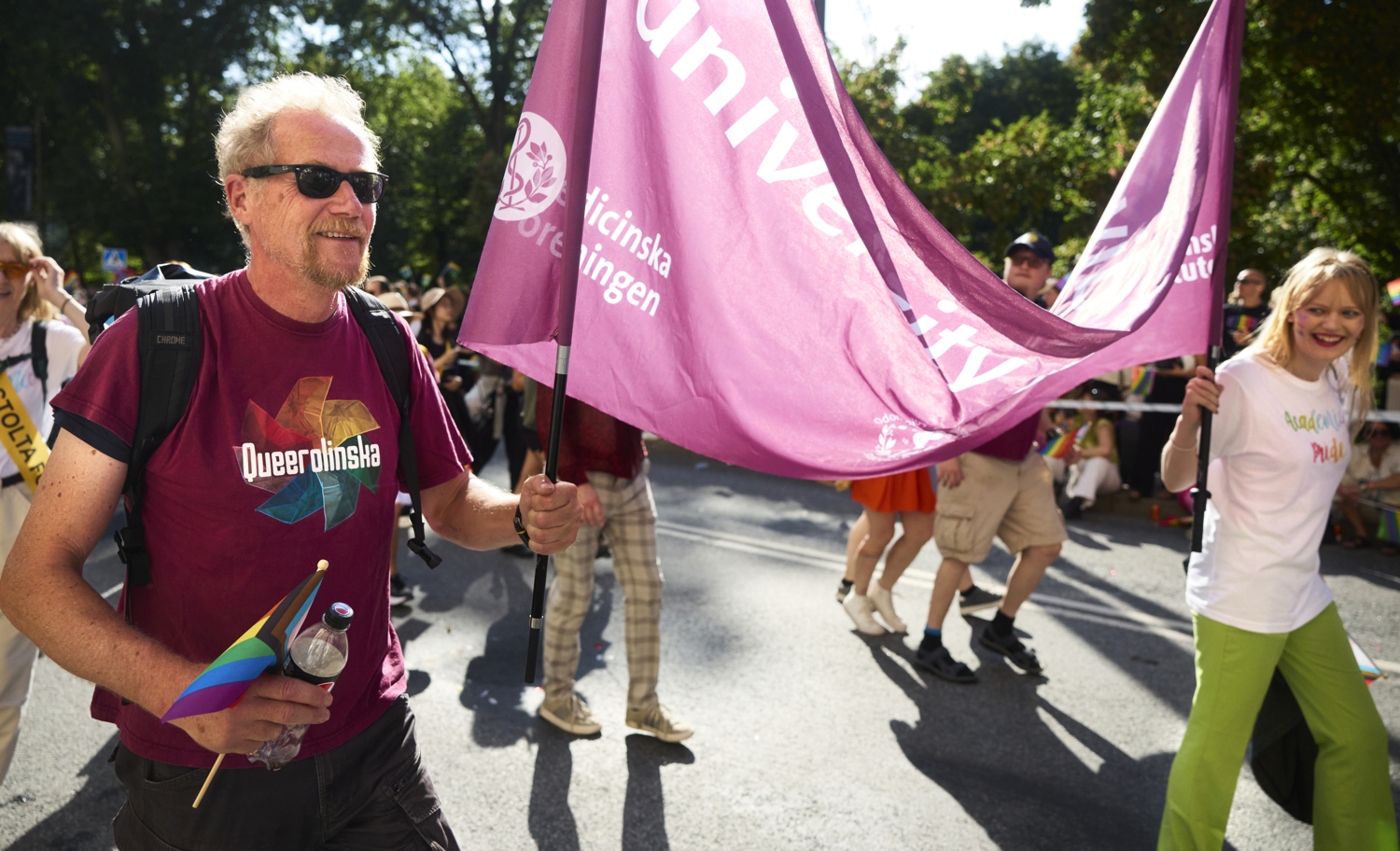 Anders Gustafsson och andra deltagare i Prideparaden. Regnbågsflaggor och glada människor..