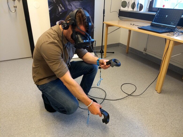 Man sitter på huk och använde VR utrustning