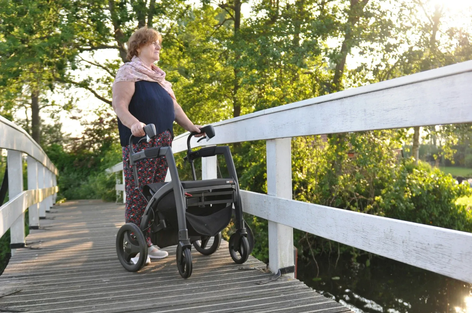 Kvinna med Parkinsons sjukdom på promenad med rullator.