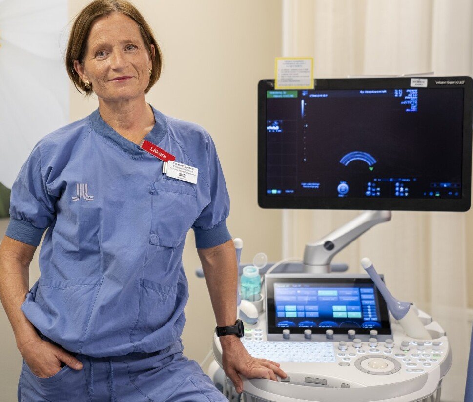 Bilden visar ett porträtt av en kvinna klädd som vårdpersonal.