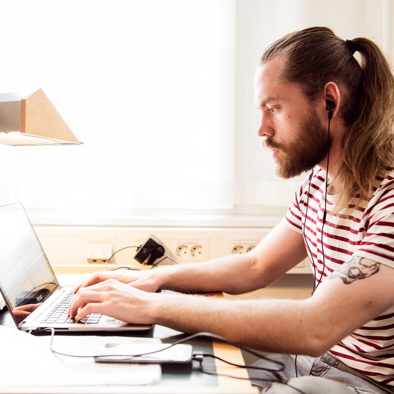 En person sitter och arbetar vid en dator.