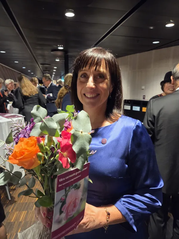 Anna Pettersson, avdelningen för fysioterapi, NVS, mottagare av KI:s pedagogiska pris 2025. Står med en stor färggrann bukett framför sig.