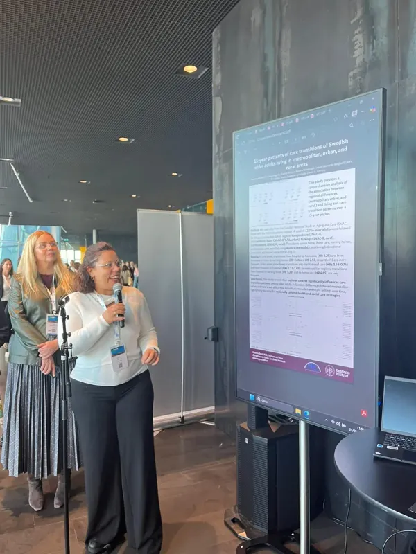 Susanna Gentili står med mikrofonen framför sin poster.
