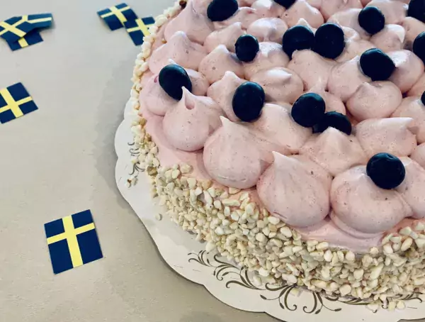 Tårta med blåbärsdekoration och svensk flagga bredvid