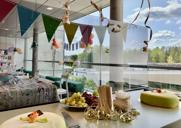 Tårtor uppdukade framför festligt dekorerade bord och Grattis i fönstret.