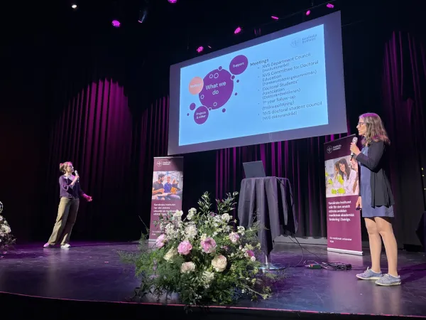 Adina König och Karin Högstedt presenterar doktorandrådet på scenen.
