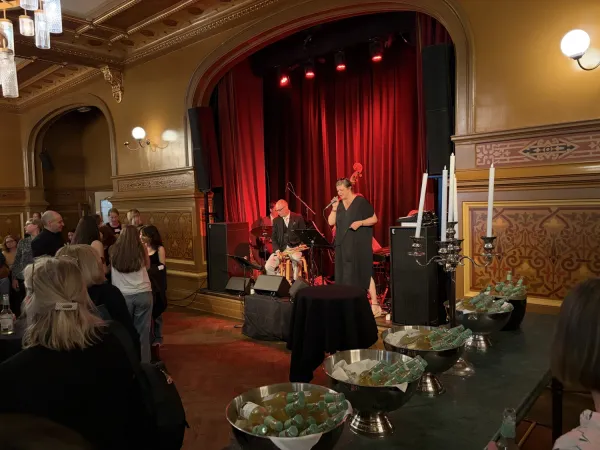 Maria Wolf sjunger jazz på scenen omgiven av musiker på trummor, bas, klaviatur och trumpet.