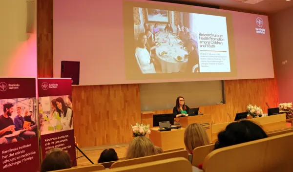 Susanne Andermo, docent i hälsovetenskap, föreläser om sin forskning vid NVS sommarlunch 2025. Hon står framme vid podiet i H1, ANA23.