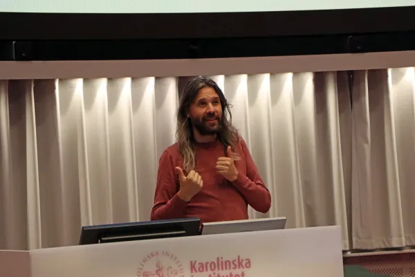 Professor Pontus Strimling, institutet för framtidsstudier, står vid ett podie och föreläser.