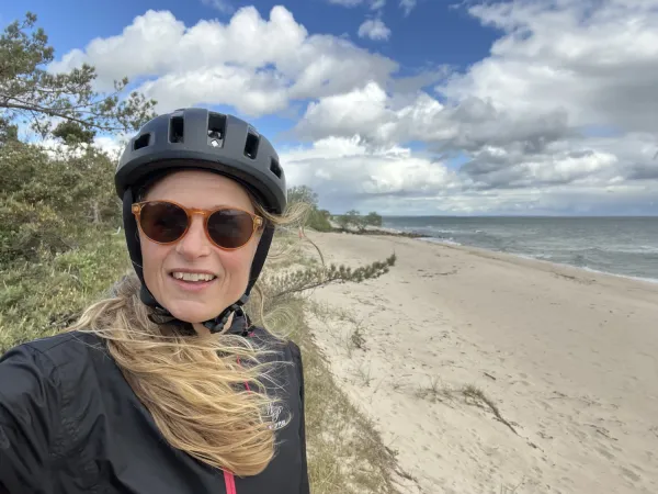 Pernilla står vid en strand på Österlen och det ser ut att blåsa en del.