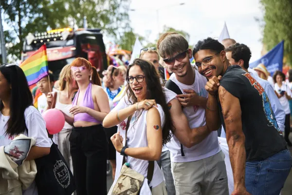 Tre KI-studenter visar sina tatueringar i Pridetåget.