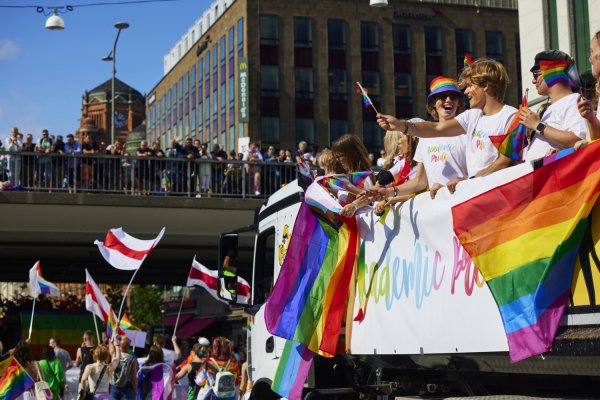 Studenter och andra deltagare i Pride-paraden. Regnbågsflaggor och glada människor..