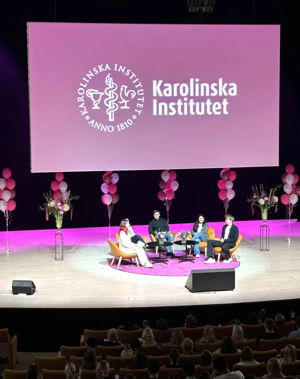 På scen en paneldiskussion med frågor till tre studenter