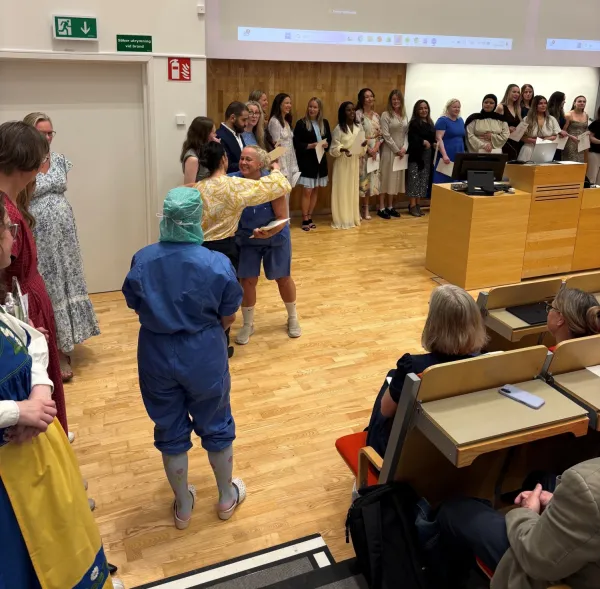 Examen för specialistsjuksköterskor, juni 2026. En grupp står framme vid podiet i H1.