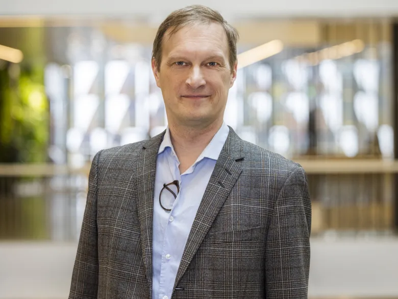 Porträtt av man i kontorsmiljö.