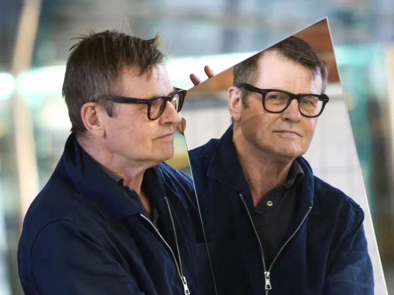 Porträtt av forskaren Mikael Benson med en spegel