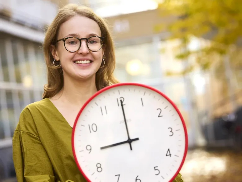 Forskaren Theresa Lemke håller i en klocka som visar 9.00.