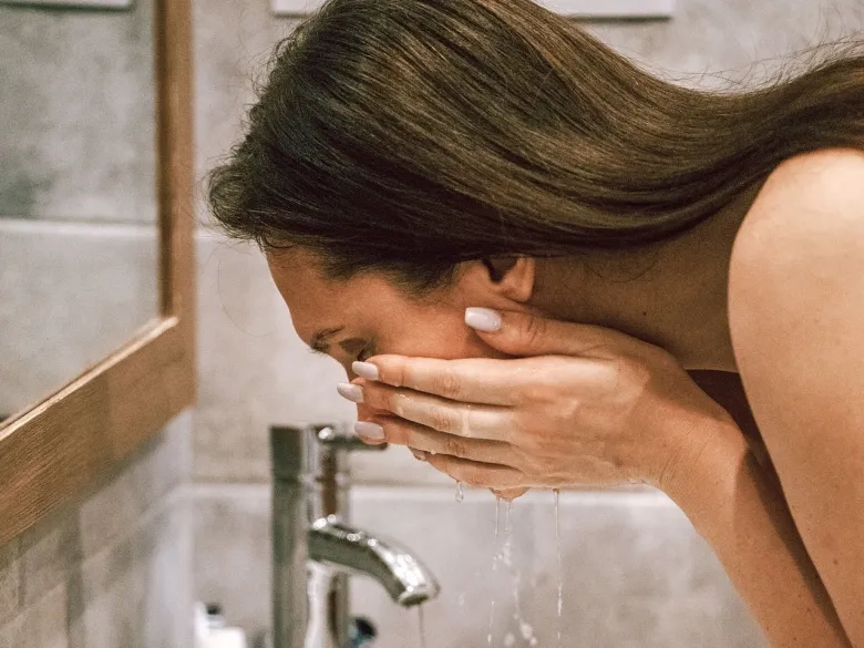 Kvinna som rengör sitt ansikte