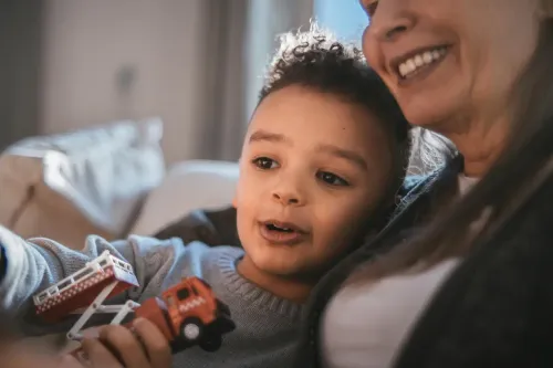 Little child with a toy car together with an older person