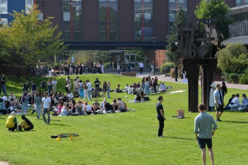 Students hanging out on the lawn outside of KIB at campus Solna during the introduction of autumn 2024.