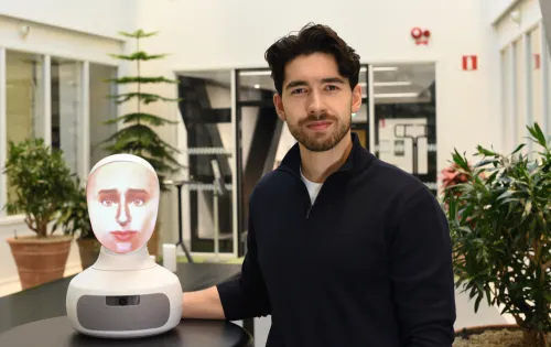 Alexander Borg, doctoral student at the Department of Medicine, Solna, next to the AI-driven robot patient used in teaching at KI.