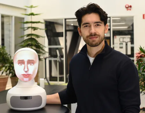 Alexander Borg, doctoral student at the Department of Medicine, Solna, next to the AI-driven robot patient used in teaching at KI.