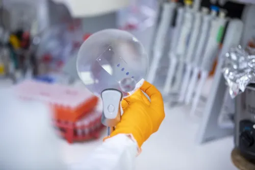 Researcher looking at tests with magnifying glass.
