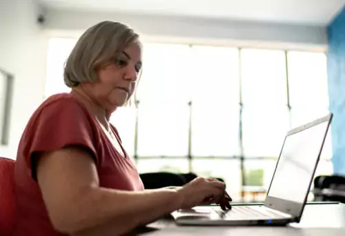 a senior woman sitting at the laptop