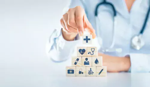 Blocks with icons representing health and healthcare stacked on top of each other like a pyramid.