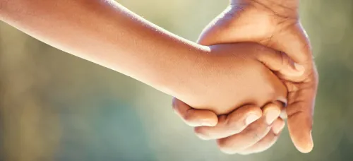 Adult and child holding hands