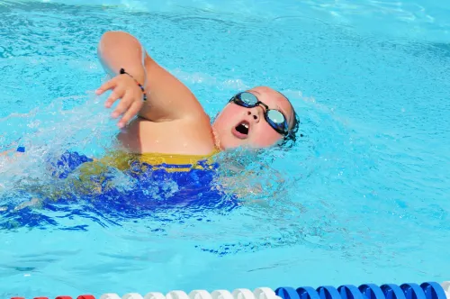 Young girl with obesity swimming.