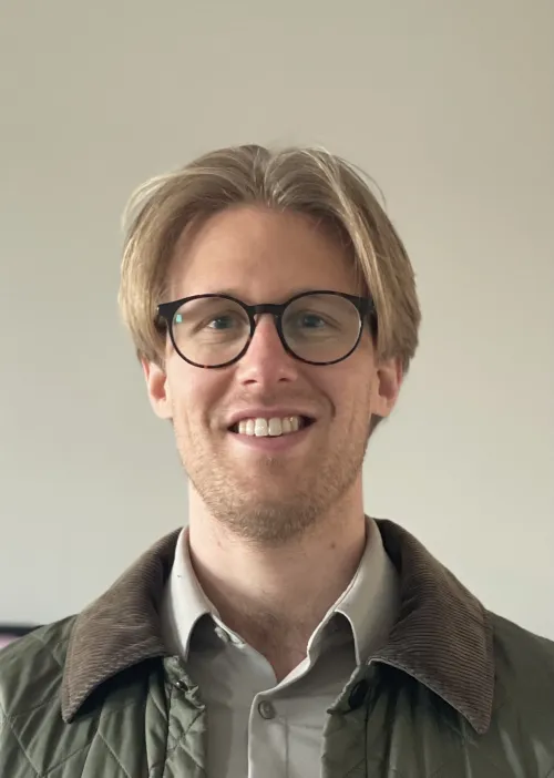Portrait of a blonde man wearing glasses.