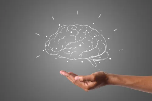a brain hovers over a hand.