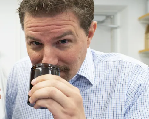 Johan Lundström smelling on something in a jar.